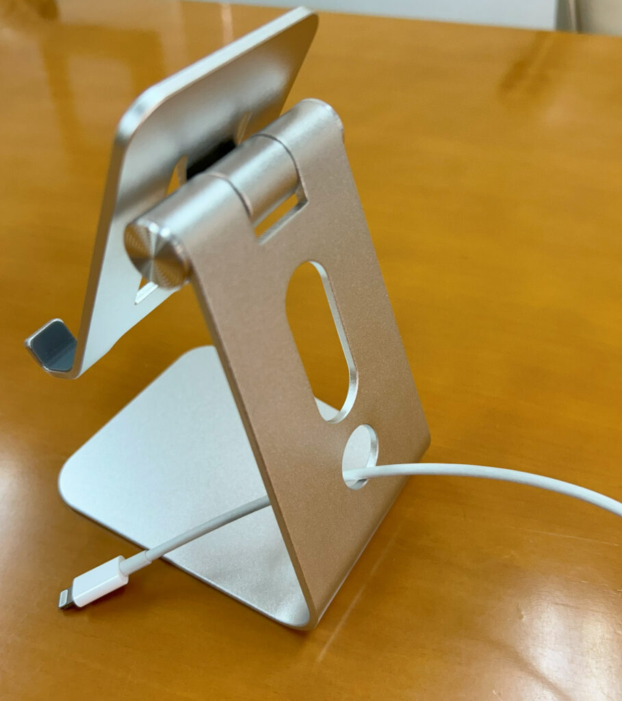 スタンドの後ろから充電ケーブルを通している様子