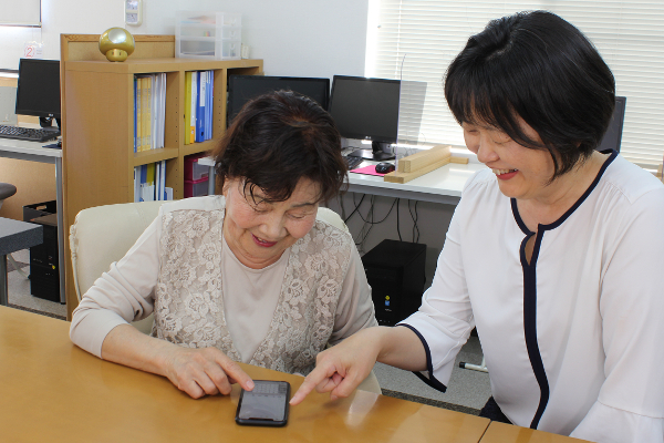 シニア女性がスマホ講座を受けている様子