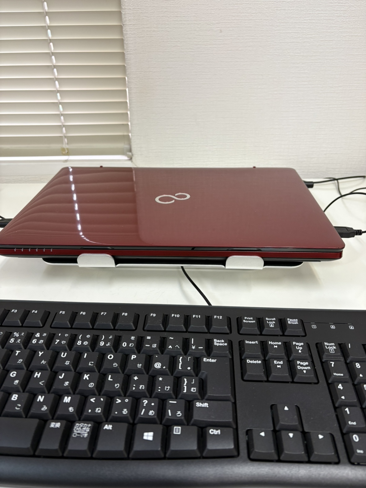 低い高さや角度で設置したノートパソコンスタンドの使用例