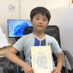 タイピングコンテストで銀賞を受賞し、賞状を持つ小学3年生の生徒