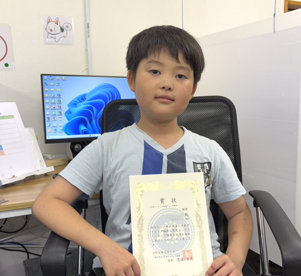 タイピングコンテストで銀賞を受賞し、賞状を持つ小学3年生の生徒
